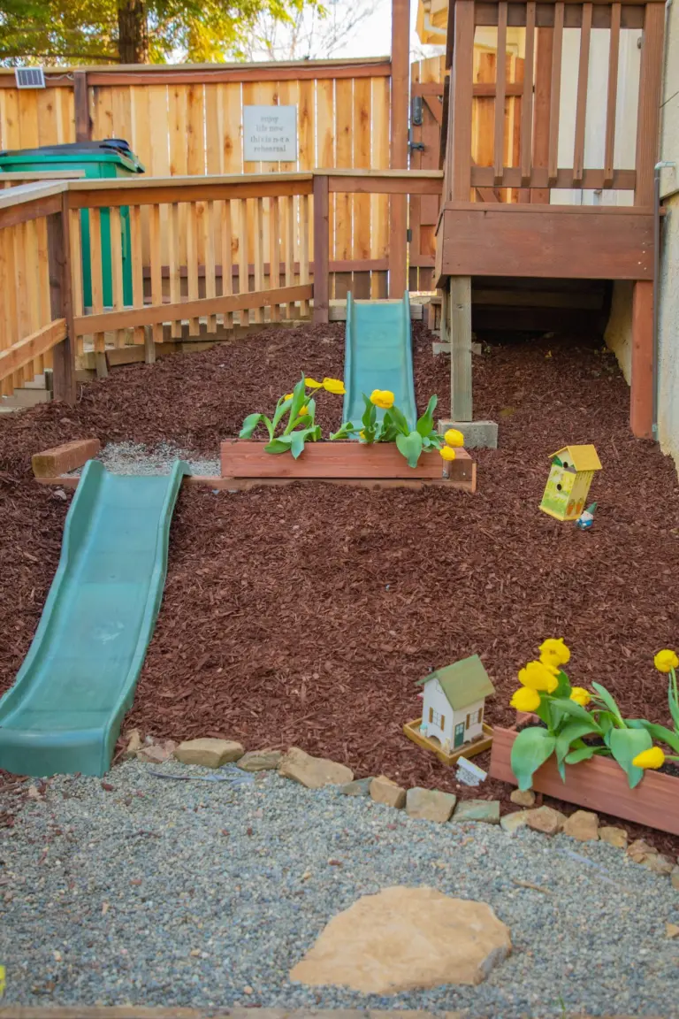 A little slide and flower beds along the terraced garden path behind the school