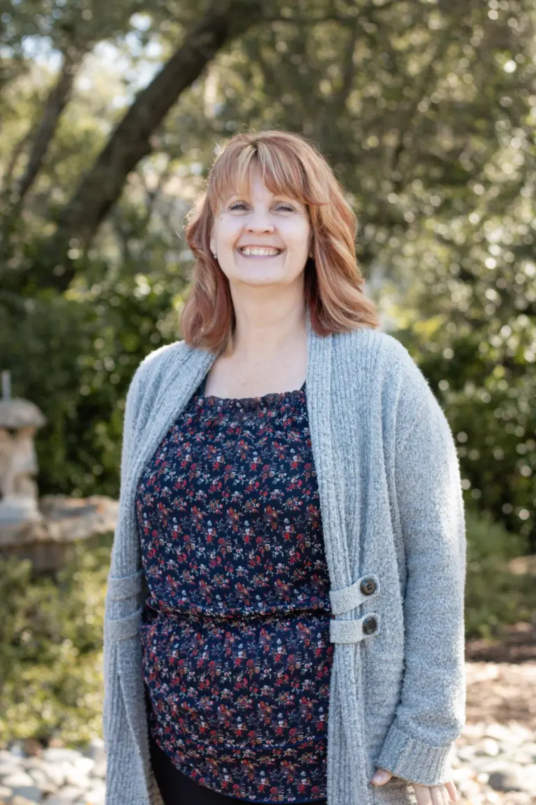 Leah Pulido smiling outdoors in a grey cardigan