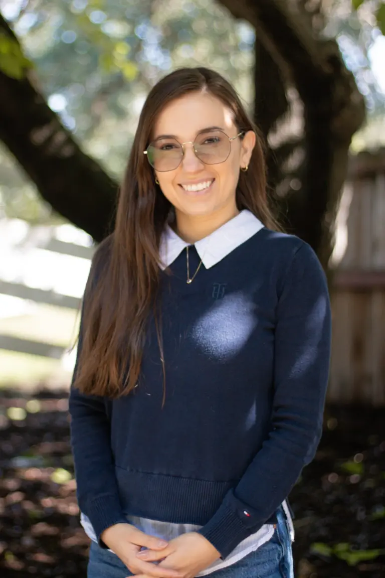 Rubi Nuño smiling outdoors in a navy sweater
