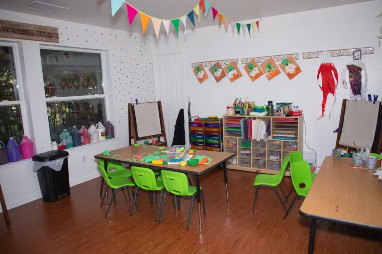 The El Dorado Hills classroom with bright green chairs, a painting easel and art supplies on the shelves